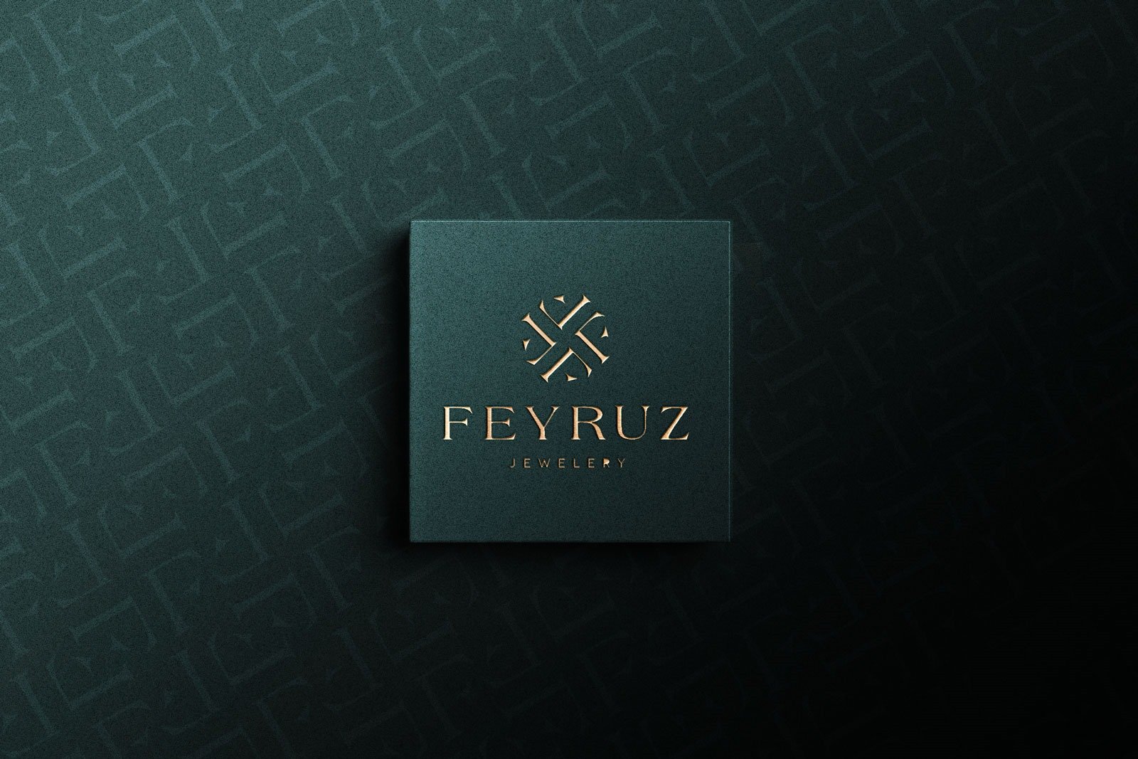 Koyu petrol yeşili kart üzerinde bakır kabartma Feyruz Jewelery logosu, arka planda harflerden oluşan desen